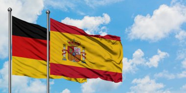 Almanya ve İspanya bayrağı birlikte beyaz bulutlu mavi gökyüzüne karşı rüzgarsal sallayarak. Diplomasi kavramı, uluslararası ilişkiler.