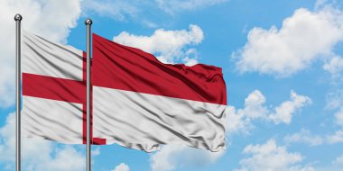 İngiltere ve Endonezya bayrağı birlikte beyaz bulutlu mavi gökyüzüne karşı rüzgarsal sallayarak. Diplomasi kavramı, uluslararası ilişkiler.