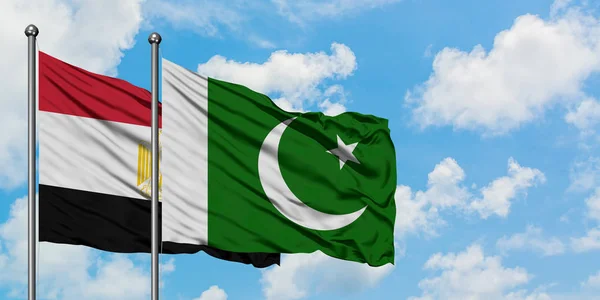Bandera de Egipto y Pakistán ondeando en el viento contra el cielo azul nublado blanco juntos. Concepto diplomático, relaciones internacionales . — Foto de Stock