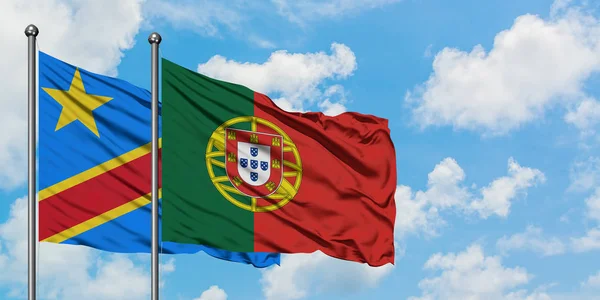 Bandeira do Congo e de Portugal agitando no vento contra o céu azul nublado branco juntos. Conceito de diplomacia, relações internacionais . — Fotografia de Stock