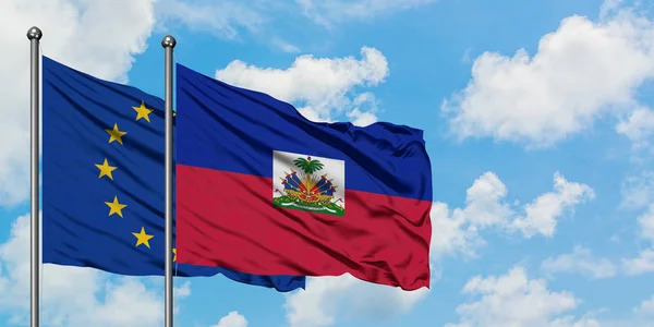 Avrupa Birliği ve Haiti bayrağı birlikte beyaz bulutlu mavi gökyüzüne karşı rüzgarda sallayarak. Diplomasi kavramı, uluslararası ilişkiler. — Stok fotoğraf