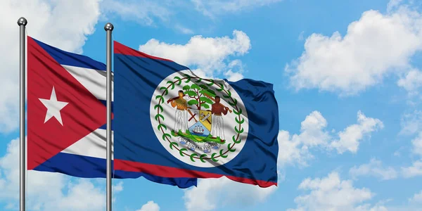 Cuba et le drapeau du Belize agitant dans le vent contre ciel bleu nuageux blanc ensemble. Concept de diplomatie, relations internationales . — Photo