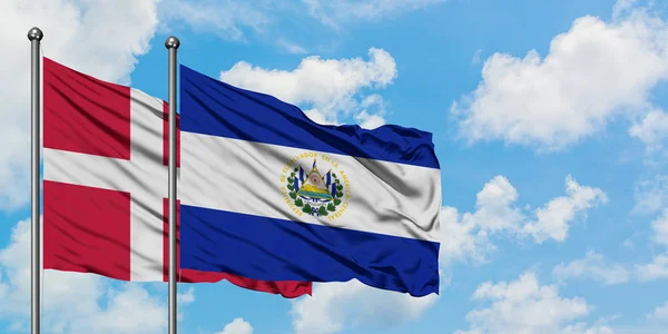 Bandera de Dinamarca y El Salvador ondeando en el viento contra el cielo azul nublado blanco juntos. Concepto diplomático, relaciones internacionales . — Foto de Stock