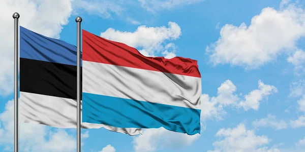 Estonia e Lussemburgo sventolano insieme la bandiera contro il bianco cielo blu nuvoloso. Concetto di diplomazia, relazioni internazionali . — Foto Stock