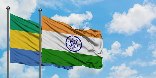 Gabon és India zászló integetett a szél ellen, fehér felhős kék ég együtt. Diplomáciai koncepció, nemzetközi kapcsolatok. — Stock Fotó