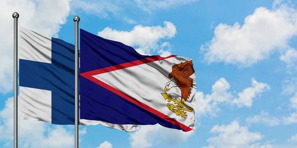 Bandera de Finlandia y Samoa Americana ondeando en el viento contra el cielo azul nublado blanco juntos. Concepto diplomático, relaciones internacionales . — Foto de Stock