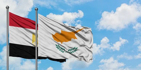 Bandera de Egipto y Chipre ondeando en el viento contra el cielo azul nublado blanco juntos. Concepto diplomático, relaciones internacionales . — Foto de Stock