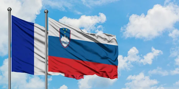 France and Slovenia flag waving in the wind against white cloudy blue sky together. Diplomacy concept, international relations. — Stock Photo, Image