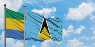 Gabon ve Saint Lucia bayrağı birlikte beyaz bulutlu mavi gökyüzüne karşı rüzgarda sallayarak. Diplomasi kavramı, uluslararası ilişkiler.