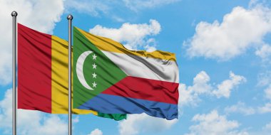 Gine ve Komorbayrağı birlikte beyaz bulutlu mavi gökyüzüne karşı rüzgarda sallayarak. Diplomasi kavramı, uluslararası ilişkiler.