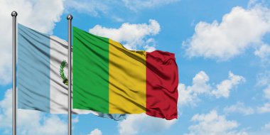 Guatemala ve Mali bayrağı birlikte beyaz bulutlu mavi gökyüzüne karşı rüzgarda sallayarak. Diplomasi kavramı, uluslararası ilişkiler.