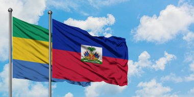 Gabon ve Haiti bayrağı birlikte beyaz bulutlu mavi gökyüzüne karşı rüzgarda sallayarak. Diplomasi kavramı, uluslararası ilişkiler.