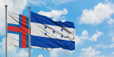 Faroe Adaları ve Honduras bayrağı birlikte beyaz bulutlu mavi gökyüzüne karşı rüzgarda sallayarak. Diplomasi kavramı, uluslararası ilişkiler.