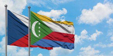 Çek Cumhuriyeti ve Komorbayrağı birlikte beyaz bulutlu mavi gökyüzüne karşı rüzgarda sallayarak. Diplomasi kavramı, uluslararası ilişkiler.