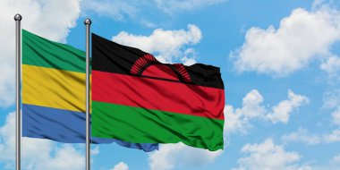 Gabon ve Malavi bayrağı birlikte beyaz bulutlu mavi gökyüzüne karşı rüzgarda sallayarak. Diplomasi kavramı, uluslararası ilişkiler.