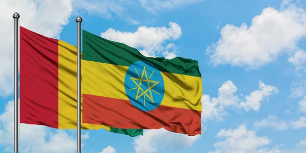 Guinea and Ethiopia flag waving in the wind against white cloudy blue sky together. Diplomacy concept, international relations. — Stock Photo, Image