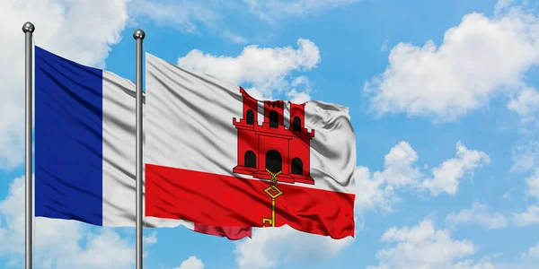 France and Gibraltar flag waving in the wind against white cloudy blue sky together. Diplomacy concept, international relations. — Stock Photo, Image