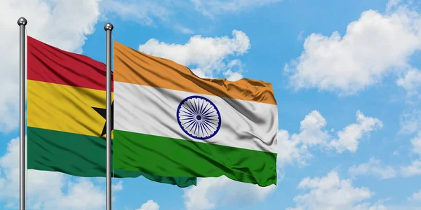 Bandera de Ghana e India ondeando en el viento contra el cielo azul nublado blanco juntos. Concepto diplomático, relaciones internacionales . — Foto de Stock