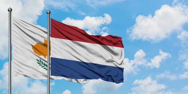 Cipro e Paesi Bassi bandiera sventolando nel vento contro bianco cielo blu nuvoloso insieme. Concetto di diplomazia, relazioni internazionali . — Foto Stock