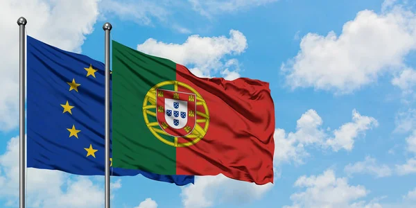 Europeiska unionen och Portugal flagga vifta i vinden mot vit grumlig blå himmel tillsammans. Diplomatisk koncept, internationella relationer. — Stockfoto