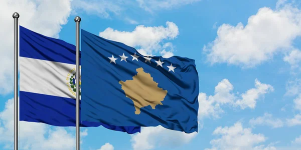 Bandera de El Salvador y Kosovo ondeando en el viento contra el cielo azul nublado blanco juntos. Concepto diplomático, relaciones internacionales . — Foto de Stock