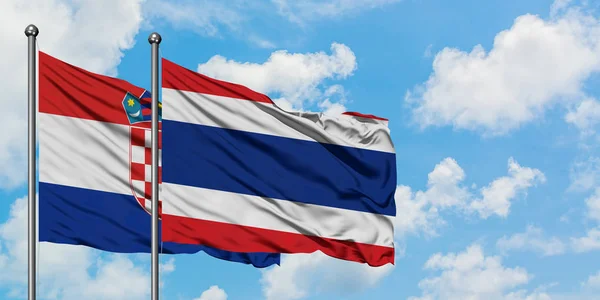 Croazia e Thailandia bandiera sventolando nel vento contro bianco cielo blu nuvoloso insieme. Concetto di diplomazia, relazioni internazionali . — Foto Stock