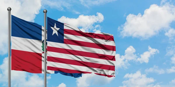 Bandera de República Dominicana y Liberia ondeando en el viento contra el cielo azul nublado blanco juntos. Concepto diplomático, relaciones internacionales . — Foto de Stock