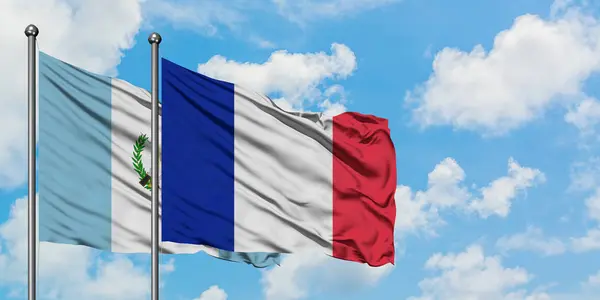 Guatemala and France flag waving in the wind against white cloudy blue sky together. Diplomacy concept, international relations. — Stock Photo, Image