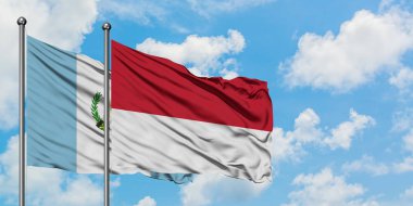 Guatemala ve Monako bayrağı birlikte beyaz bulutlu mavi gökyüzüne karşı rüzgarsal sallayarak. Diplomasi kavramı, uluslararası ilişkiler.