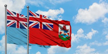 Fiji ve Bermuda bayrağı birlikte beyaz bulutlu mavi gökyüzüne karşı rüzgarda sallayarak. Diplomasi kavramı, uluslararası ilişkiler.