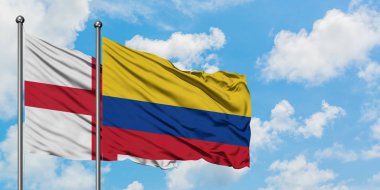 İngiltere ve Kolombiya bayrağı birlikte beyaz bulutlu mavi gökyüzüne karşı rüzgarda sallayarak. Diplomasi kavramı, uluslararası ilişkiler.