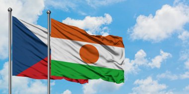 Çek Cumhuriyeti ve Nijer bayrağı birlikte beyaz bulutlu mavi gökyüzüne karşı rüzgarda sallayarak. Diplomasi kavramı, uluslararası ilişkiler.