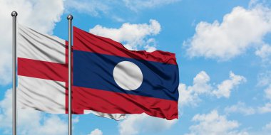 İngiltere ve Laos bayrağı birlikte beyaz bulutlu mavi gökyüzüne karşı rüzgarda sallayarak. Diplomasi kavramı, uluslararası ilişkiler.