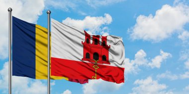 Çad ve Cebelitarık bayrağı birlikte beyaz bulutlu mavi gökyüzüne karşı rüzgarda sallayarak. Diplomasi kavramı, uluslararası ilişkiler.