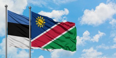 Estonya ve Namibya bayrağı birlikte beyaz bulutlu mavi gökyüzüne karşı rüzgarda sallayarak. Diplomasi kavramı, uluslararası ilişkiler.