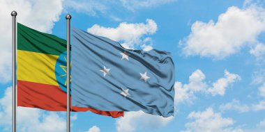 Etiyopya ve Mikronezya bayrağı birlikte beyaz bulutlu mavi gökyüzüne karşı rüzgarda sallayarak. Diplomasi kavramı, uluslararası ilişkiler.