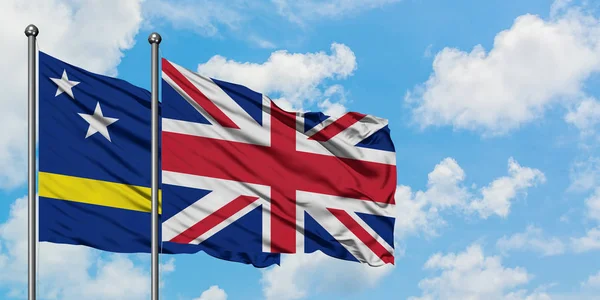 큐라소와 영국 국기가 함께 하얀 흐린 푸른 하늘에 바람을 흔들고. 외교 개념, 국제 관계. — 스톡 사진