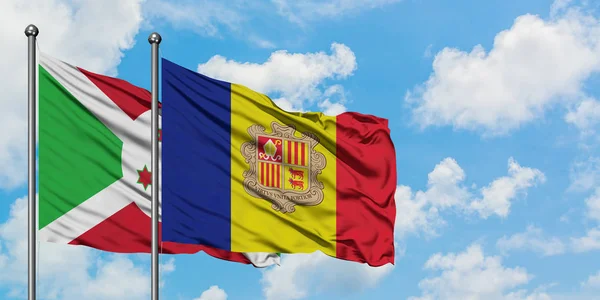 Bandera de Burundi y Andorra ondeando en el viento contra el cielo azul nublado blanco juntos. Concepto diplomático, relaciones internacionales . — Foto de Stock