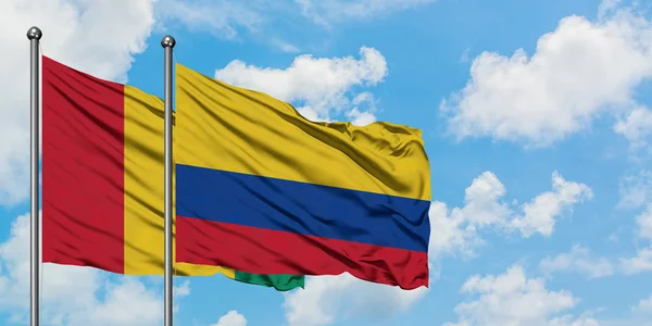 Η σημαία της Γουινέας και της Κολομβίας κουνώντας τον άνεμο ενάντια στον λευκό θολό γαλάζιο ουρανό μαζί. Φιλοσοφία της διπλωματίας, διεθνείς σχέσεις. — Φωτογραφία Αρχείου