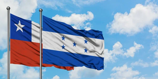 Bandeira do Chile e Honduras agitando no vento contra o céu azul nublado branco juntos. Conceito de diplomacia, relações internacionais . — Fotografia de Stock