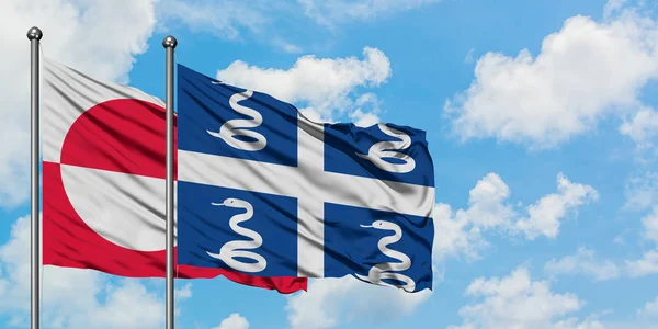 Drapeau du Groenland et de la Martinique agitant dans le vent contre ciel bleu nuageux blanc ensemble. Concept de diplomatie, relations internationales . — Photo