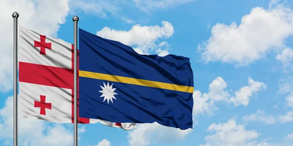 Bandera de Georgia y Nauru ondeando en el viento contra el cielo azul nublado blanco juntos. Concepto diplomático, relaciones internacionales . — Foto de Stock