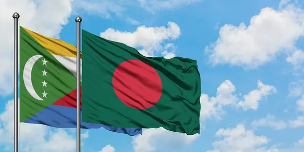 Bandera de Comoras y Bangladesh ondeando en el viento contra el cielo azul nublado blanco juntos. Concepto diplomático, relaciones internacionales . — Foto de Stock