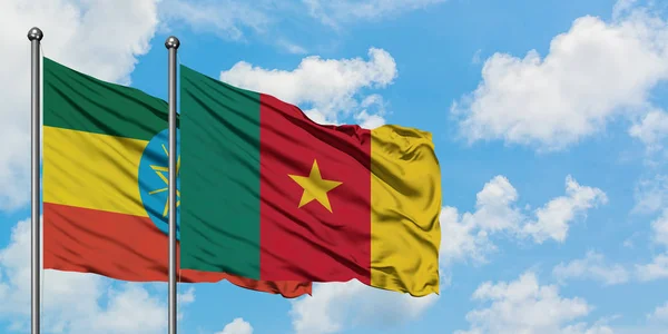 Bandera de Etiopía y Camerún ondeando en el viento contra el cielo azul nublado blanco juntos. Concepto diplomático, relaciones internacionales . — Foto de Stock