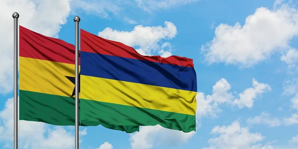 Bandera de Ghana y Mauricio ondeando en el viento contra el cielo azul nublado blanco juntos. Concepto diplomático, relaciones internacionales . — Foto de Stock