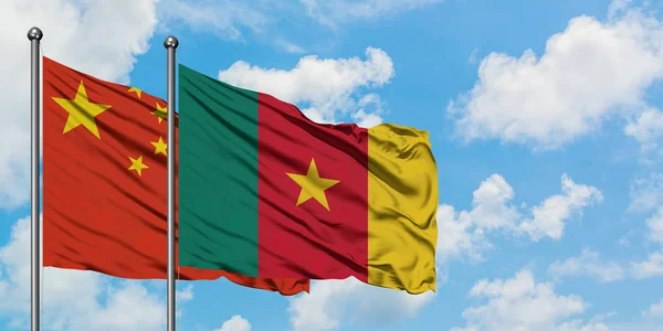 Kina og Cameroun flag vinker i vinden mod hvid overskyet blå himmel sammen. Diplomati koncept, internationale relationer . - Stock-foto