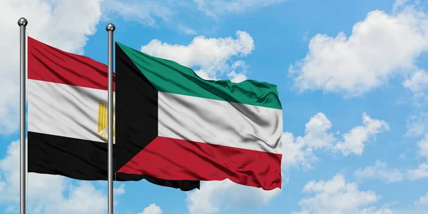 Bandera de Egipto y Kuwait ondeando en el viento contra el cielo azul nublado blanco juntos. Concepto diplomático, relaciones internacionales . — Foto de Stock