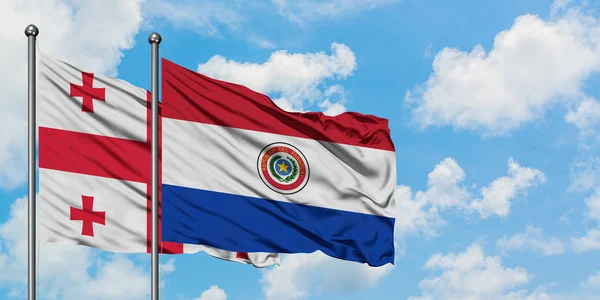 Грузія і Парагвай прапор розмахуючи в вітер проти білого хмарного синього неба разом. Концепція дипломатії, міжнародні відносини. — стокове фото