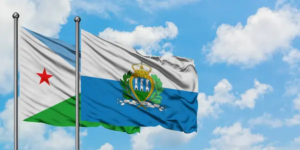 지부티와 산마리노 깃발이 하얀 흐린 푸른 하늘을 배경으로 바람에 흔들리고 있습니다. 외교 개념, 국제 관계. — 스톡 사진