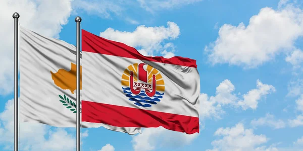 Cypern och franska Polynesien flagga vinka i vinden mot vit grumlig blå himmel tillsammans. Diplomatisk koncept, internationella relationer. — Stockfoto